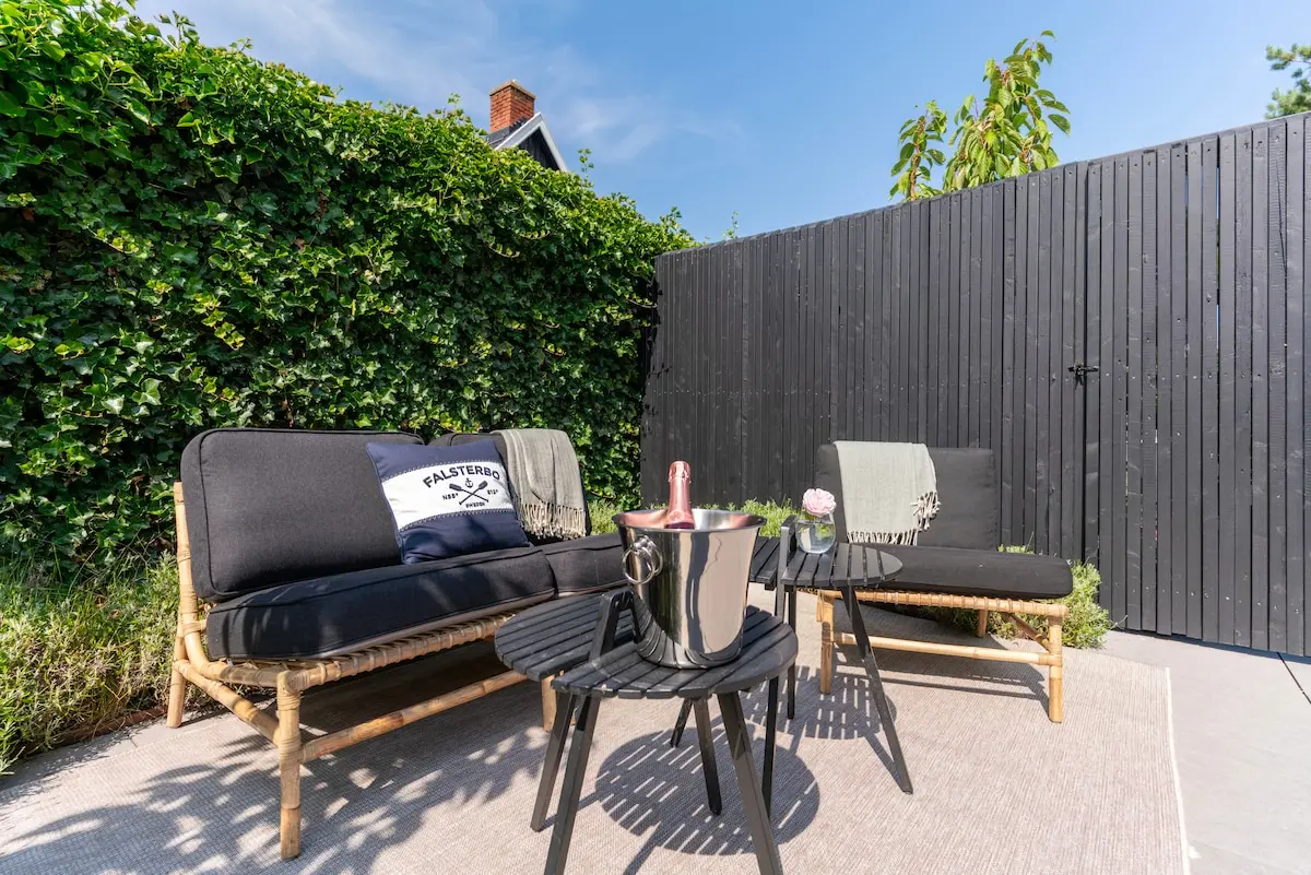 Patio with green hedges and lounge furniture