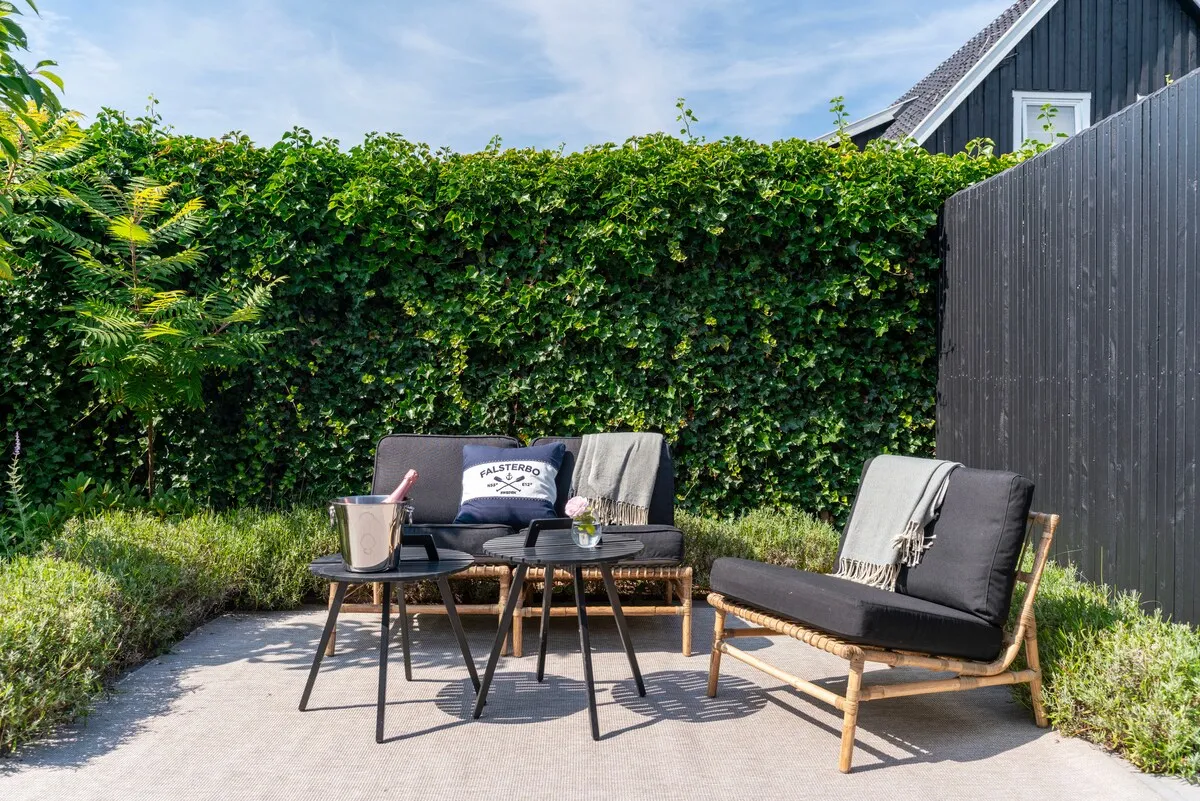 Private patio with lounge furniture and hedges